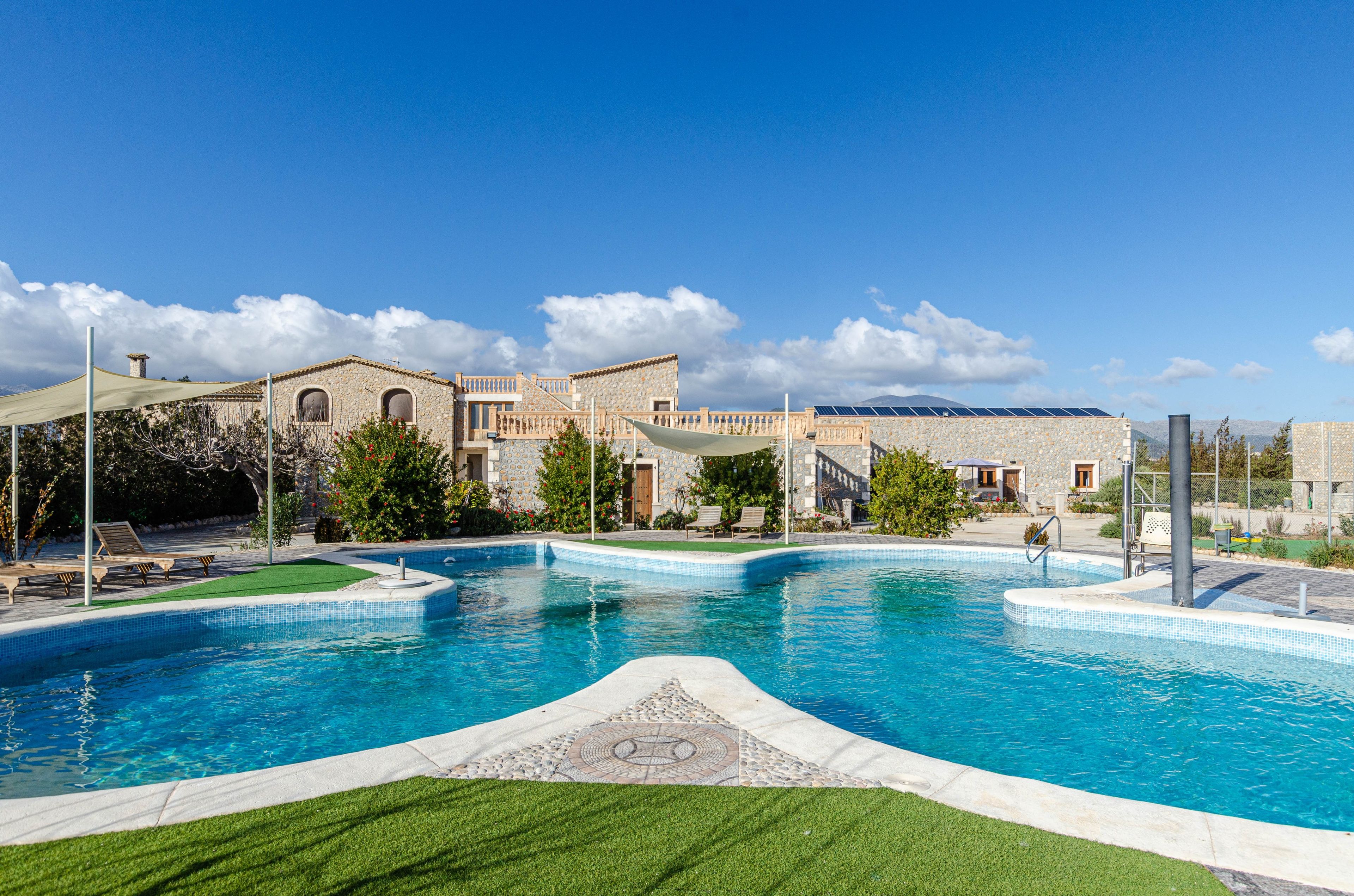 A swimming pool with a stone facade building in the background.