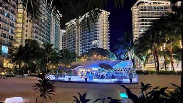 Un hotel con varios edificios altos, una piscina y palmeras.