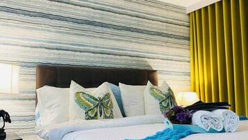 A hotel room with a bed, a nightstand, a lamp, and a window with curtains.