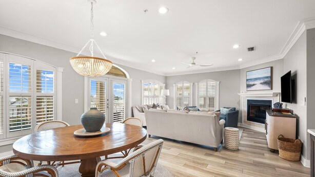 A spacious dining area with a round wooden table, wicker chairs, and a large vase centerpiece. - 3BR Seagrove Beach Pet-Friendly Penthouse | Private Beach & Pool (Santa Rosa Beach)