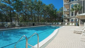 A swimming pool with a metal ladder, surrounded by a white fence and lounge chairs. - Pet-Friendly 6BR Seagrove Penthouses | Private Beach & Pool (Santa Rosa Beach)