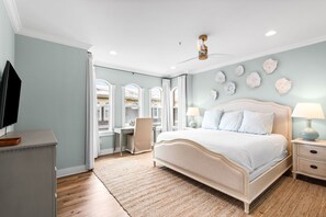 Ein Schlafzimmer mit einem Bett, Nachttischen, einem Schreibtisch und einem Stuhl.