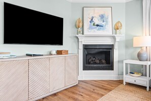 A living room with a flat-screen TV mounted on the wall, a fireplace with a mantel, and a side table with a lamp. - Pet-Friendly 6BR Seagrove Penthouses | Private Beach & Pool (Santa Rosa Beach)