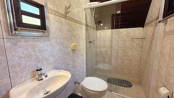 A bathroom with a sink, toilet, and shower area.