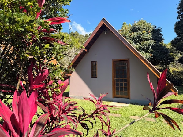 Una casa con techo triangular, puerta de madera y una ventana.