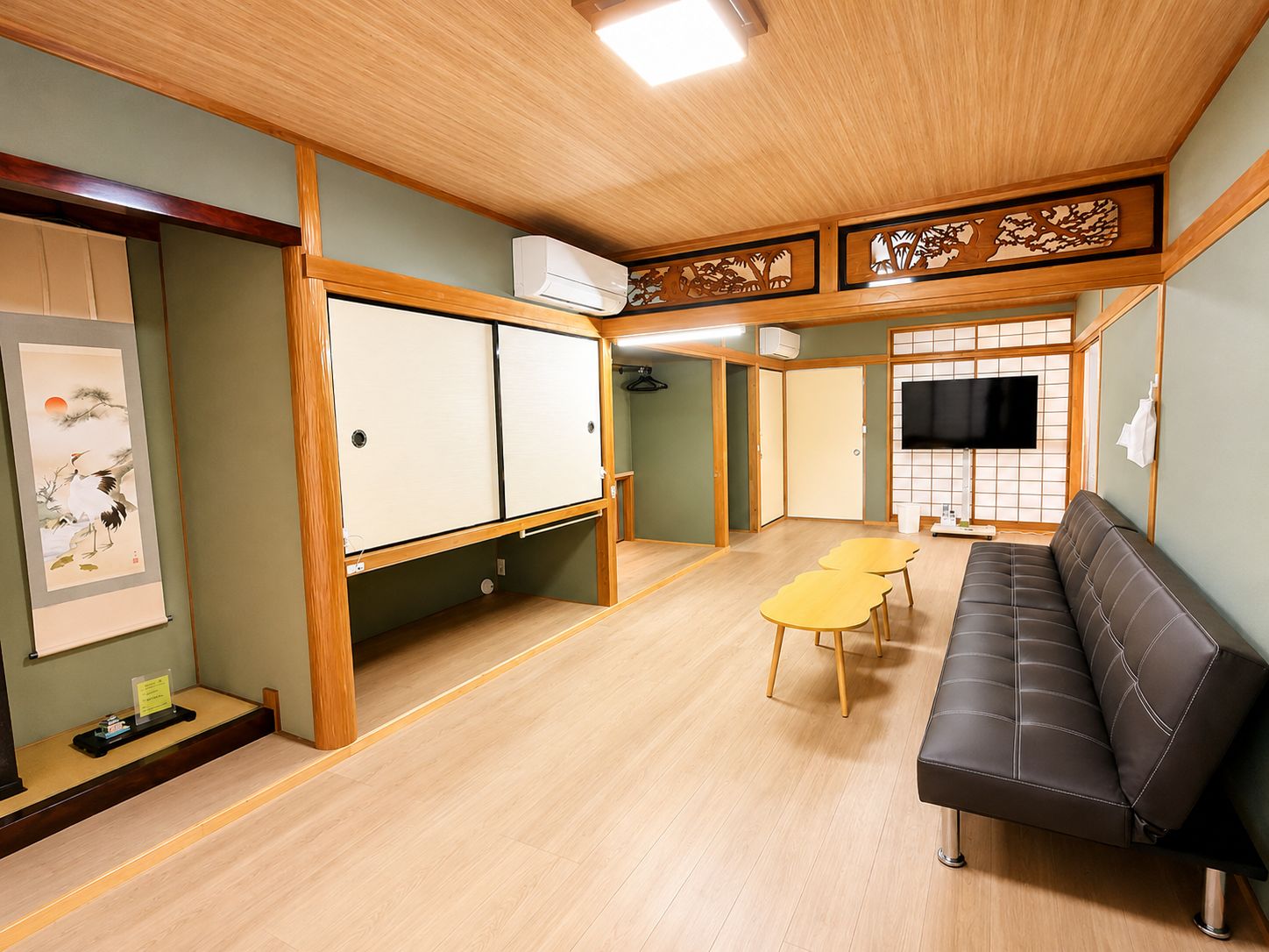 A room with a sofa, a table, a TV, and a sliding door.