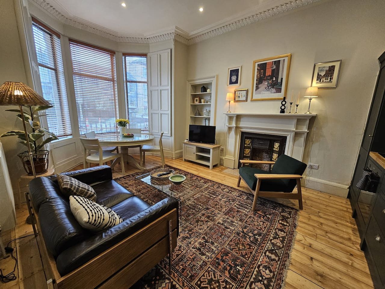 A living room with a sofa, armchair, and a fireplace.