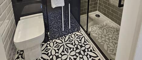 A bathroom with a shower, sink, and toilet.