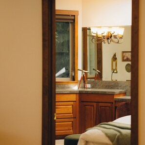 A bathroom with wooden cabinets, a sink, and a mirror. - Dreamy Castle in the woods with ocean views, hot tub, private gazebo & glowing sunsets—just minutes from Olympic National Park. (Port Angeles)