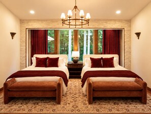 A hotel room with two beds, a chandelier, a large window with curtains, and a patterned carpet. - Dreamy Castle in the woods with ocean views, hot tub, private gazebo & glowing sunsets—just minutes from Olympic National Park. (Port Angeles)