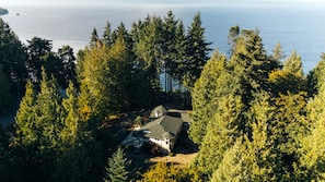 Ein Haus, von dichtem Wald umgeben, mit Blick auf den Ozean.