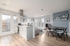A modern apartment with a kitchen, dining area, and a balcony. - Central Edinburgh 2 Bed Apt near Royal Mile (Edinburgh)