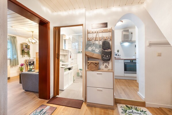 A modern interior with a wooden floor, a kitchen area with a built-in oven, and a bathroom with a shower and toilet.