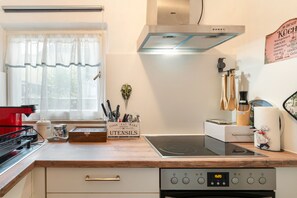 A kitchen with a stove, oven, and a box of utensils.