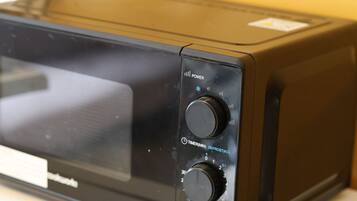 Un four à micro-ondes doté de deux boutons, l’un portant l’inscription « PUISSANCE » et l’autre « DÉCONGÉLATION (KG) ».