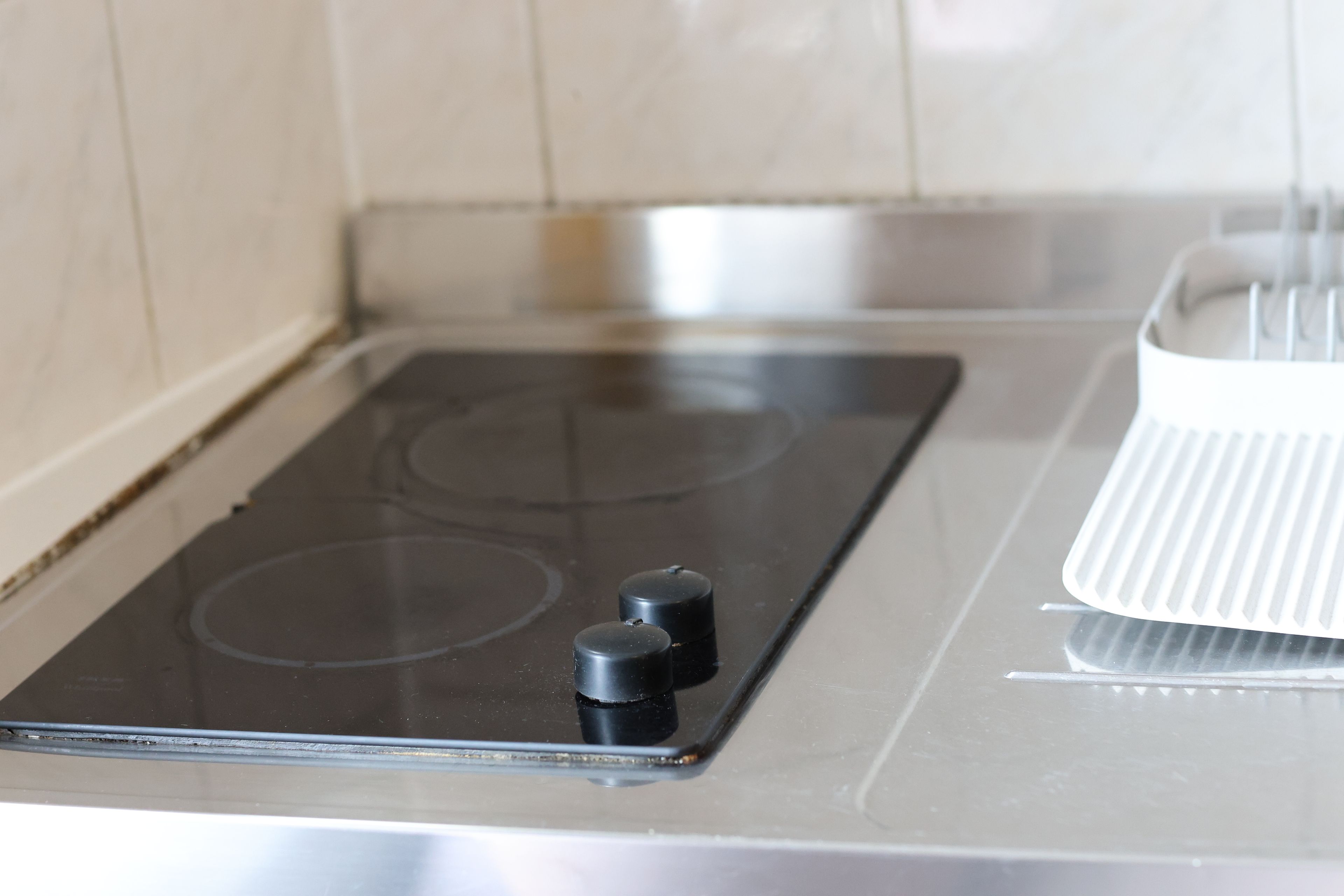 Une cuisine avec un four et un appareil électroménager blanc, peut-être un cuiseur à riz, posé sur un plan de travail.