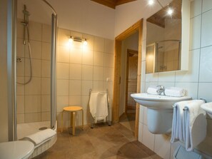 A bathroom with a shower, toilet, sink, and a small wooden stool. - Cabin in Annaberg With Swimming Pool (Annaberg-Lungoetz)