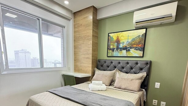 A modern bedroom with a bed, a window, and an air conditioning unit. - Vrbo Property (Sacramenta)
