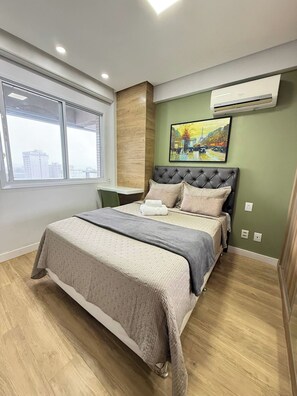 Une chambre à coucher moderne, avec un lit, une fenêtre et un appareil de climatisation.
