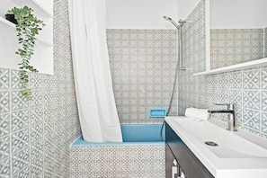 A bathroom with a shower, a sink, and a mirror. - Elegant Apartment Near Eiffel Tower (Paris)