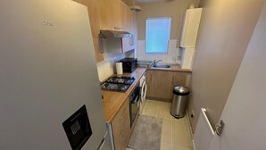 Una cocina compacta con estufa integrada, microondas y pileta.