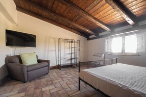 A room with a bed, a sofa, a TV mounted on the wall, and a window with blinds. - Oasi Orange villa with Jacuzzi (Sicilia)