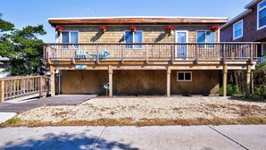 A two-story building with a wooden deck and a fenced front yard. - Pet-Friendly, 5 min walk to beach & ferry (Ocean Beach)