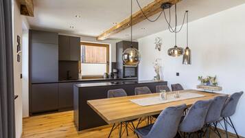 A modern kitchen with a central island, dark cabinetry, and pendant lighting.