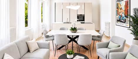 A modern living room with a dining area, featuring a sofa set, a coffee table, and a dining table with chairs.