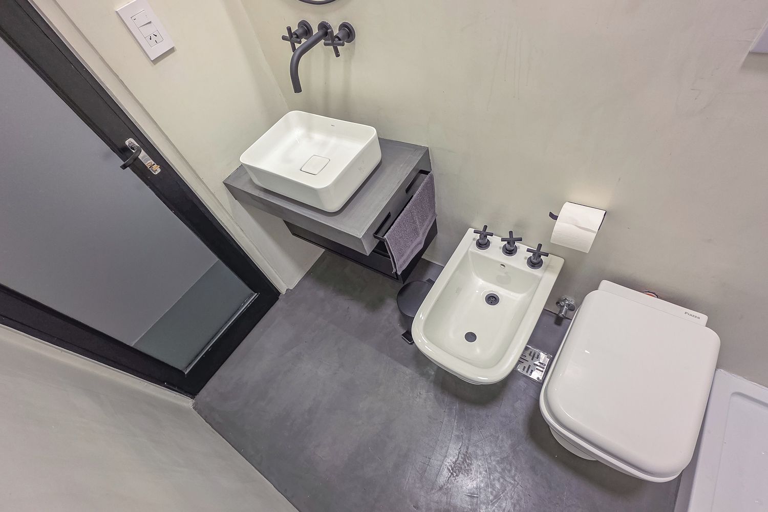A bathroom with a white sink, a bidet, and a toilet.