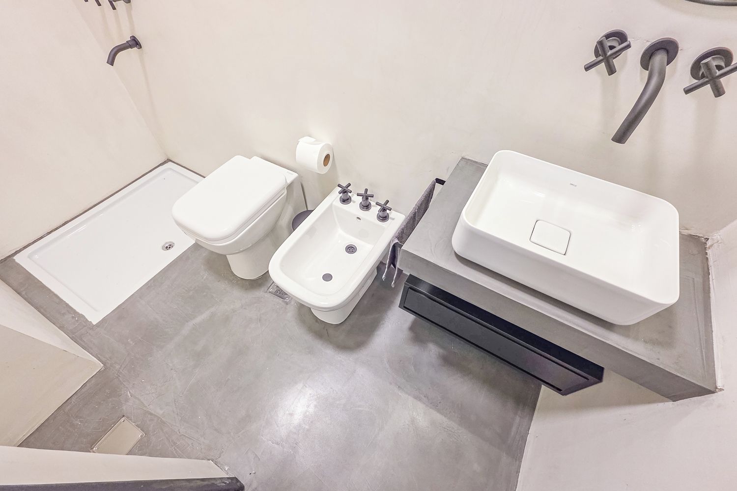A compact bathroom with a toilet, bidet, and a sink.