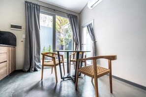 A room with a dining table and chairs, a window with curtains, and a view of greenery outside. - MOT River Plate Lux Lofts (Buenos Aires)