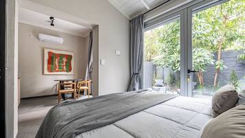 Un dormitorio con una cama grande, un escritorio, una silla, una ventana con cortinas y un cuadro en la pared.