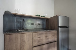 A kitchen with a stainless steel refrigerator, a sink with a modern faucet, wooden cabinets, and a countertop. - MOT River Plate Lux Lofts (Buenos Aires)