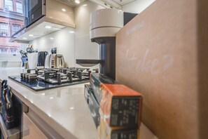 A kitchen with a coffee machine, a kettle, and a toaster.