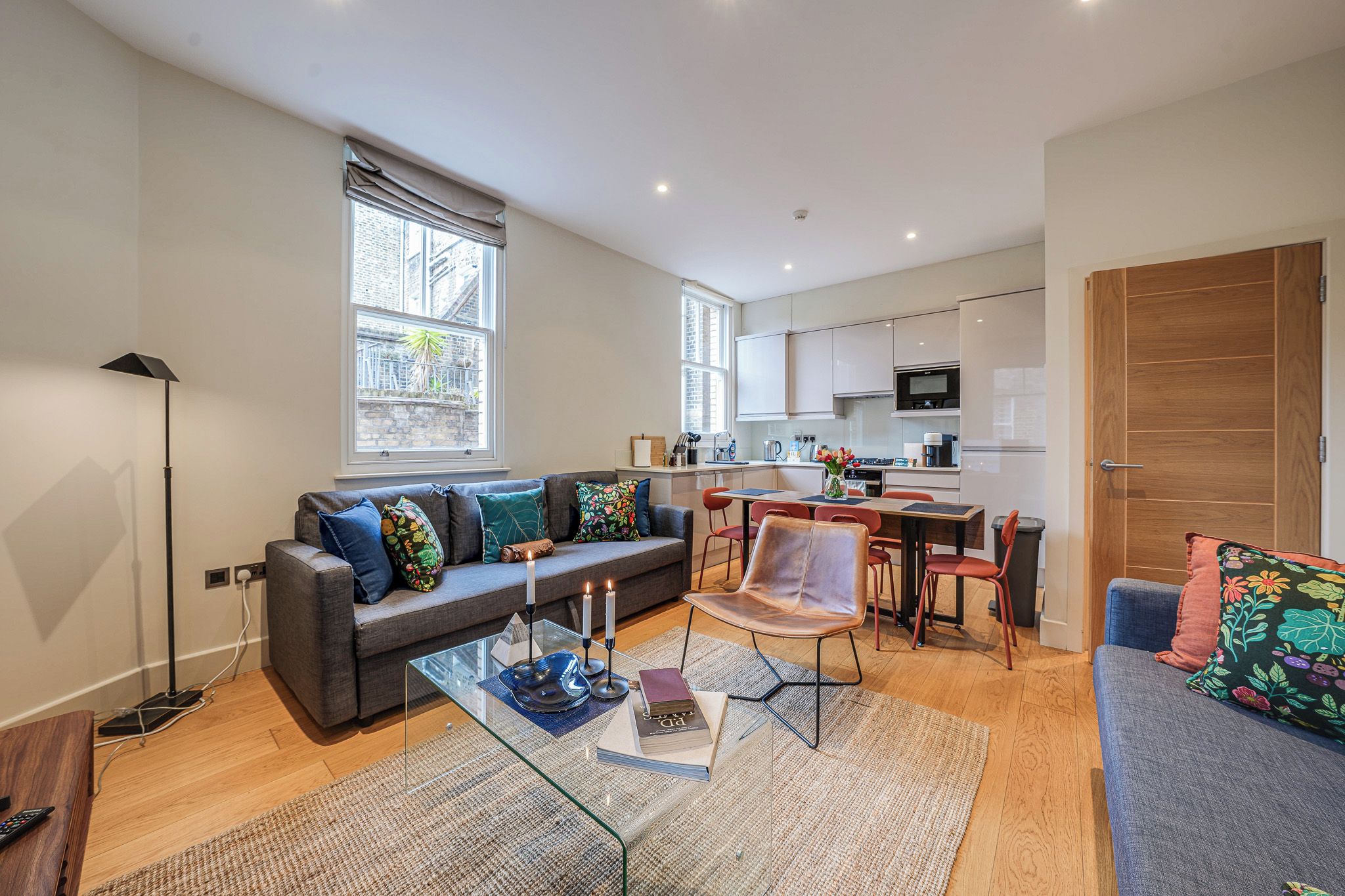 A modern apartment with a living room, kitchen, and dining area.