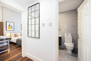 A hotel room with a bed, bedside table, and a framed artwork on the wall. - 102 Great Titchfield Street Residence (London)