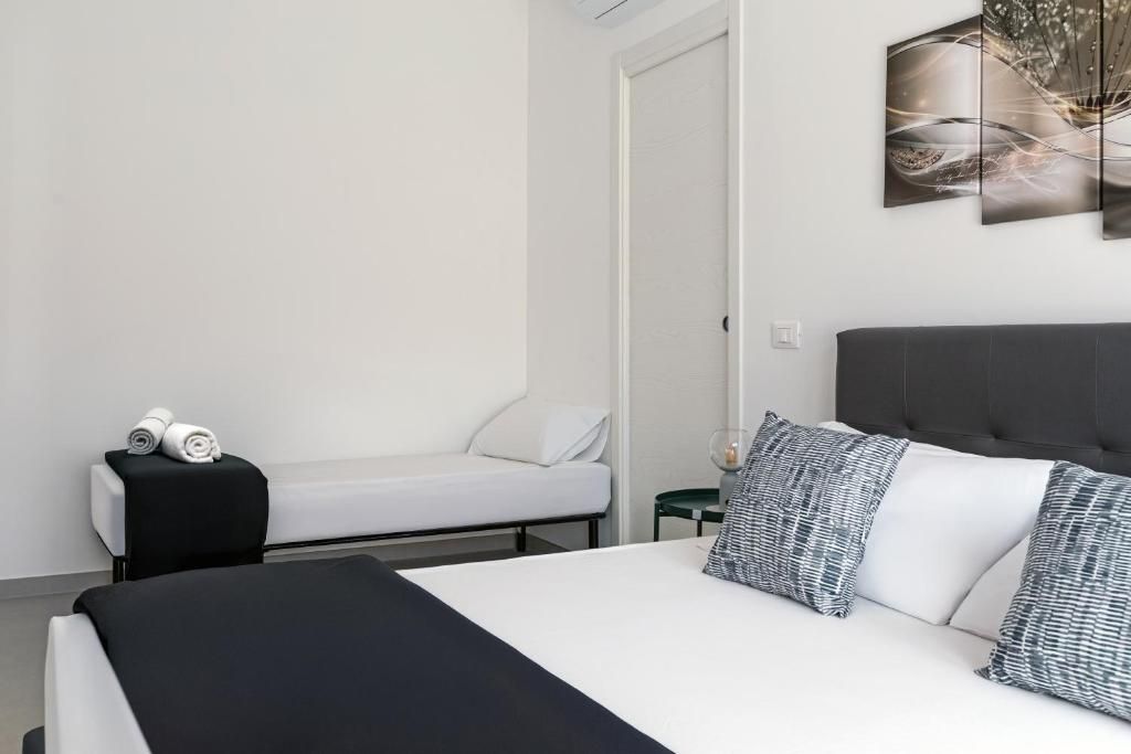 Ein modernes Schlafzimmer mit einem Bett, einem Nachttisch, einem Sessel und einem an der Wand befestigten Kunstwerk.