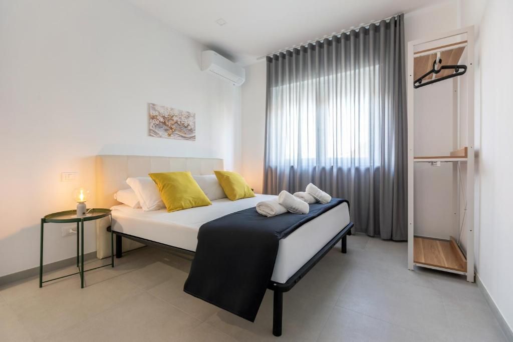 Ett modernt hotellrum med en säng, ett sängbord och en garderob.