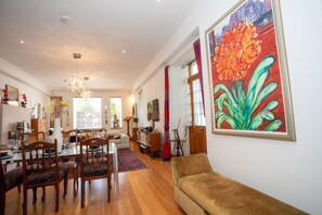 A spacious living room with a dining area, a large painting, and a sofa. - The Banking Hall -  a house  that sleeps 6 guests  in 2 bedrooms (Brightons)