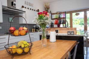 A kitchen counter with a fruit basket, a vase with flowers, and a coffee maker. - The Banking Hall -  a house  that sleeps 6 guests  in 2 bedrooms (Brightons)