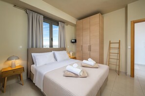 Une chambre d’hôtel avec un lit, une armoire, une table de chevet avec une lampe, une fenêtre avec des rideaux et une vue sur la ville.