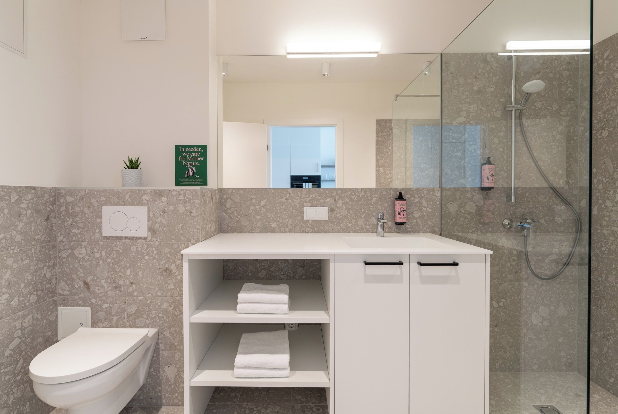 Un baño moderno con inodoro, lavamanos y ducha.