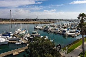A marina with numerous boats docked, a clear sky, and a distant shoreline. - 25% Off Sept, Perfect For Families, Walk To Beach! (Ventura)