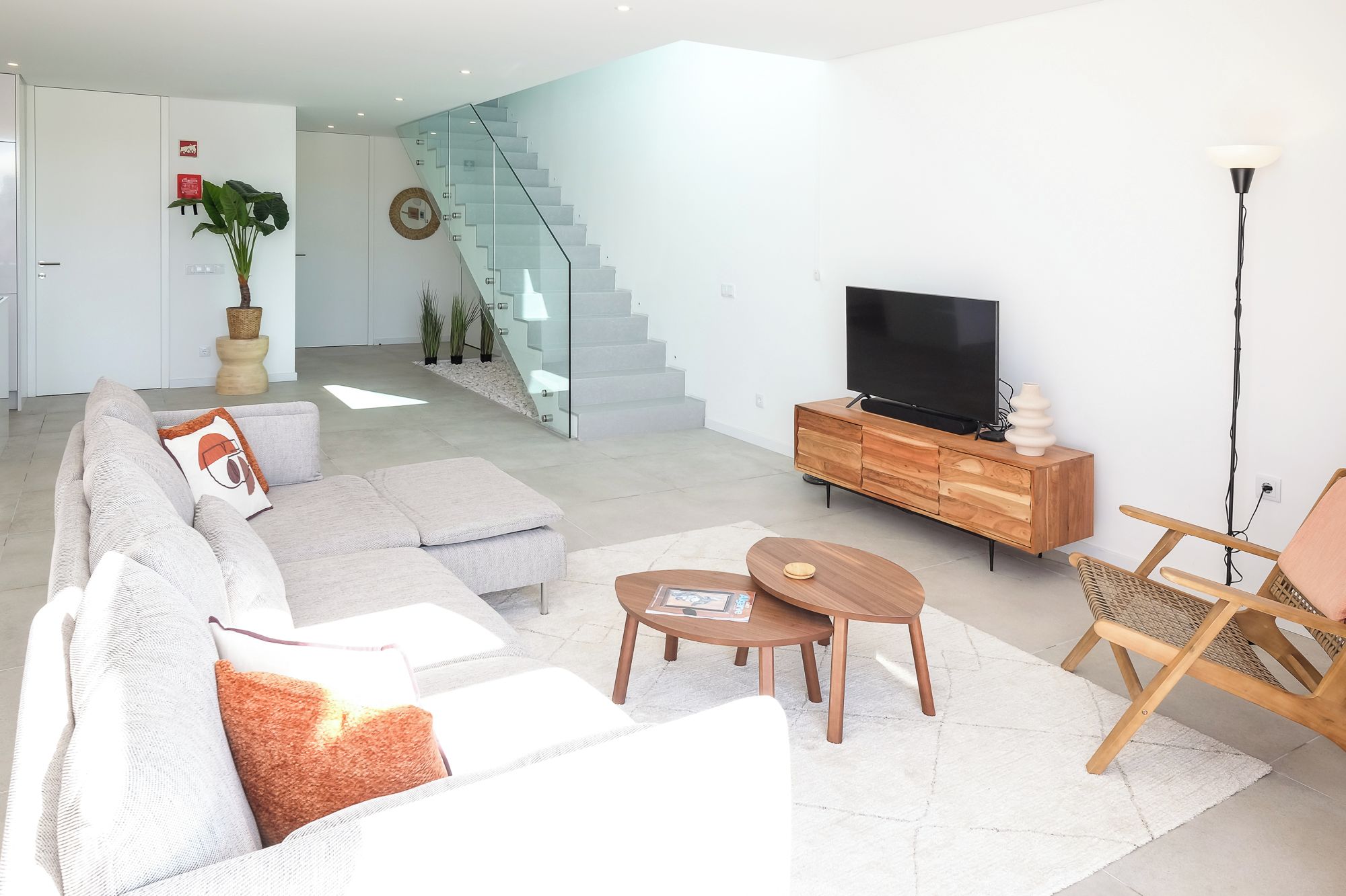 A modern living room with a sofa, coffee table, and TV stand.