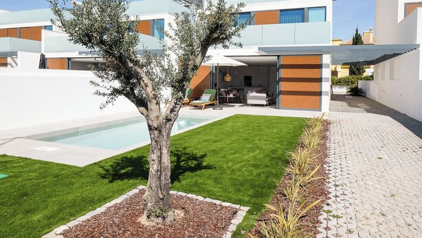 Ein modernes Wohnhaus mit Swimmingpool, gepflegtem Rasen und einer Terrassenfläche.