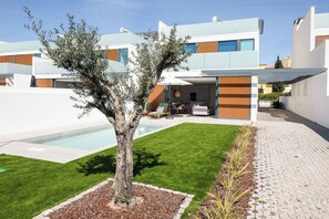 Una propietat residencial moderna amb piscina, gespa ben cuidada i zona de terrassa.