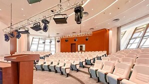 A conference room with rows of chairs, a podium, and stage lighting. - Arba Minch Conference Resort  (Arba Minch)