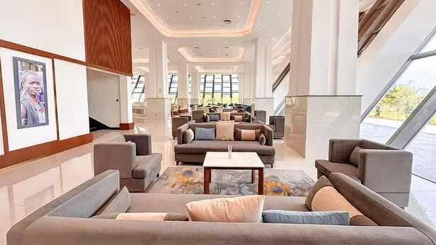 A spacious lobby with a modern design, featuring a central seating area with sofas and a coffee table, large windows providing natural light, and a view of the outdoors. - Arba Minch Conference Resort  (Arba Minch)
