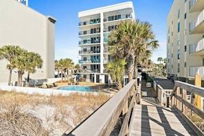 A multi-story hotel with a pool area, outdoor seating, and a wooden boardwalk. - Gorgeous Beach View Condo! Free Dolphin Cruise (Fort Walton Beach)